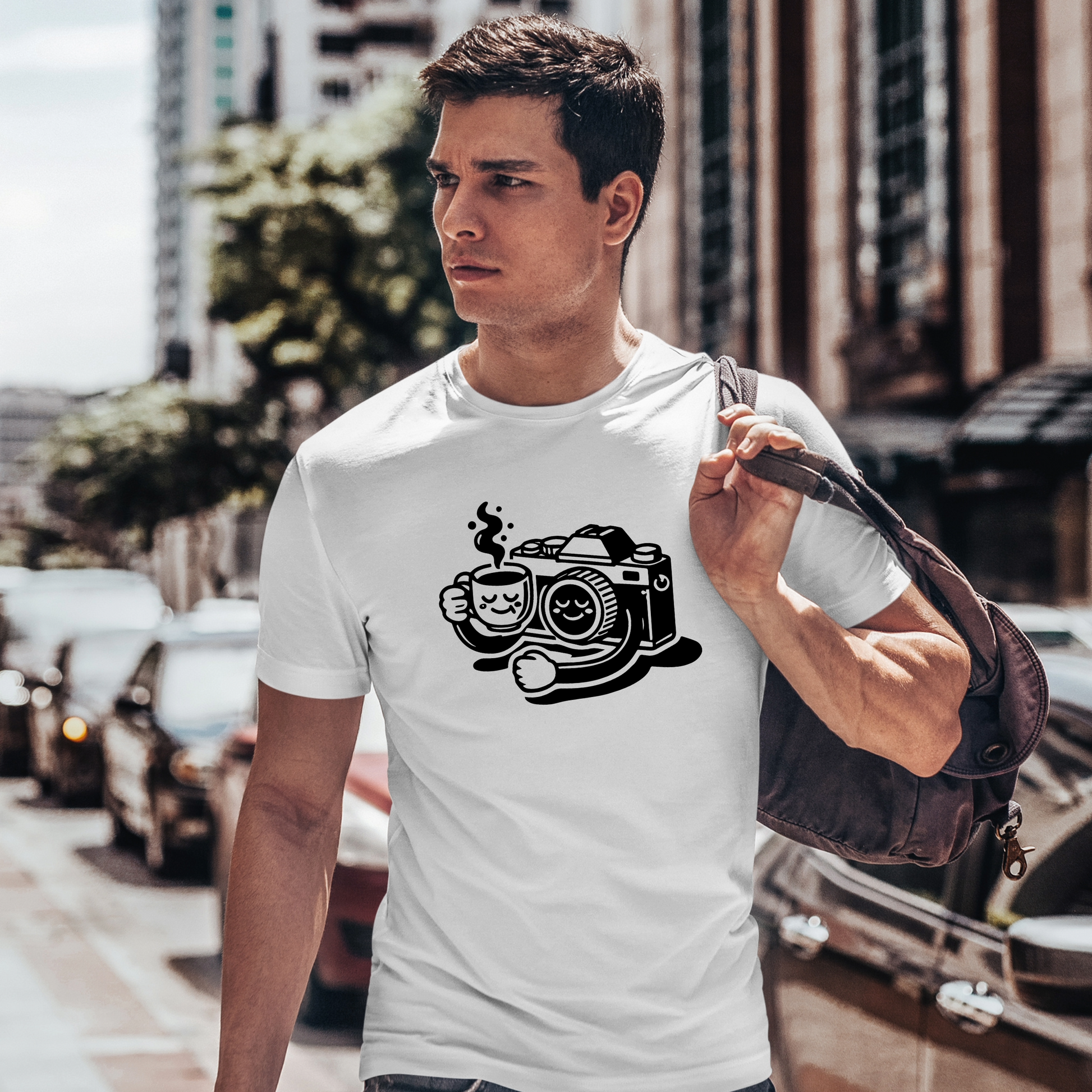 (T-shirt indossata da uomo in città):
Modello indossa una t-shirt bianca con il design “Coffee & Clicks - Il Relax del Fotografo”, mentre cammina in città con una borsa a tracolla, perfetta per i fotografi sempre in movimento.