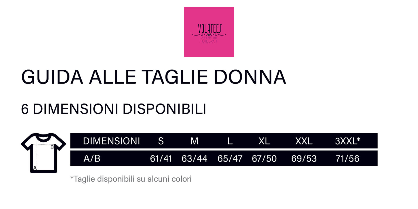 Tabella della guida alle taglie per le t-shirt donna VOLATEES. Mostra sei dimensioni disponibili (S, M, L, XL, XXL, 3XXL*) con relative misure in centimetri per lunghezza (A) e larghezza (B). Il logo VOLATEES è posizionato in alto al centro su sfondo rosa. Una nota in basso specifica che alcune taglie sono disponibili solo in determinati colori