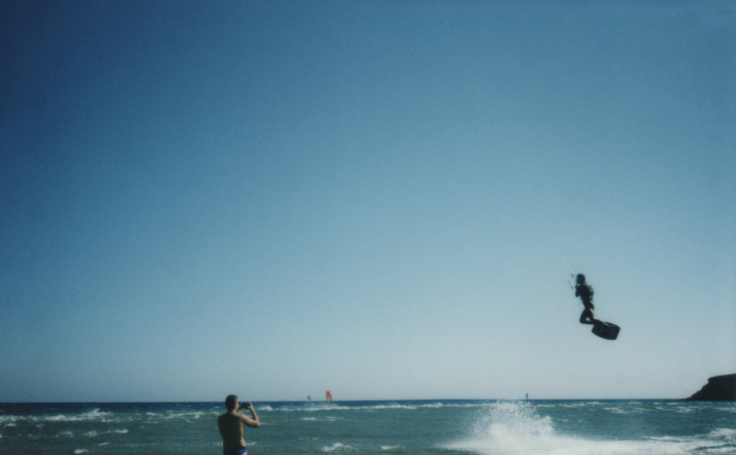 "Stampa Polaroid – Kitesurfer sospeso in aria sopra le onde, catturato in un momento di pura adrenalina."