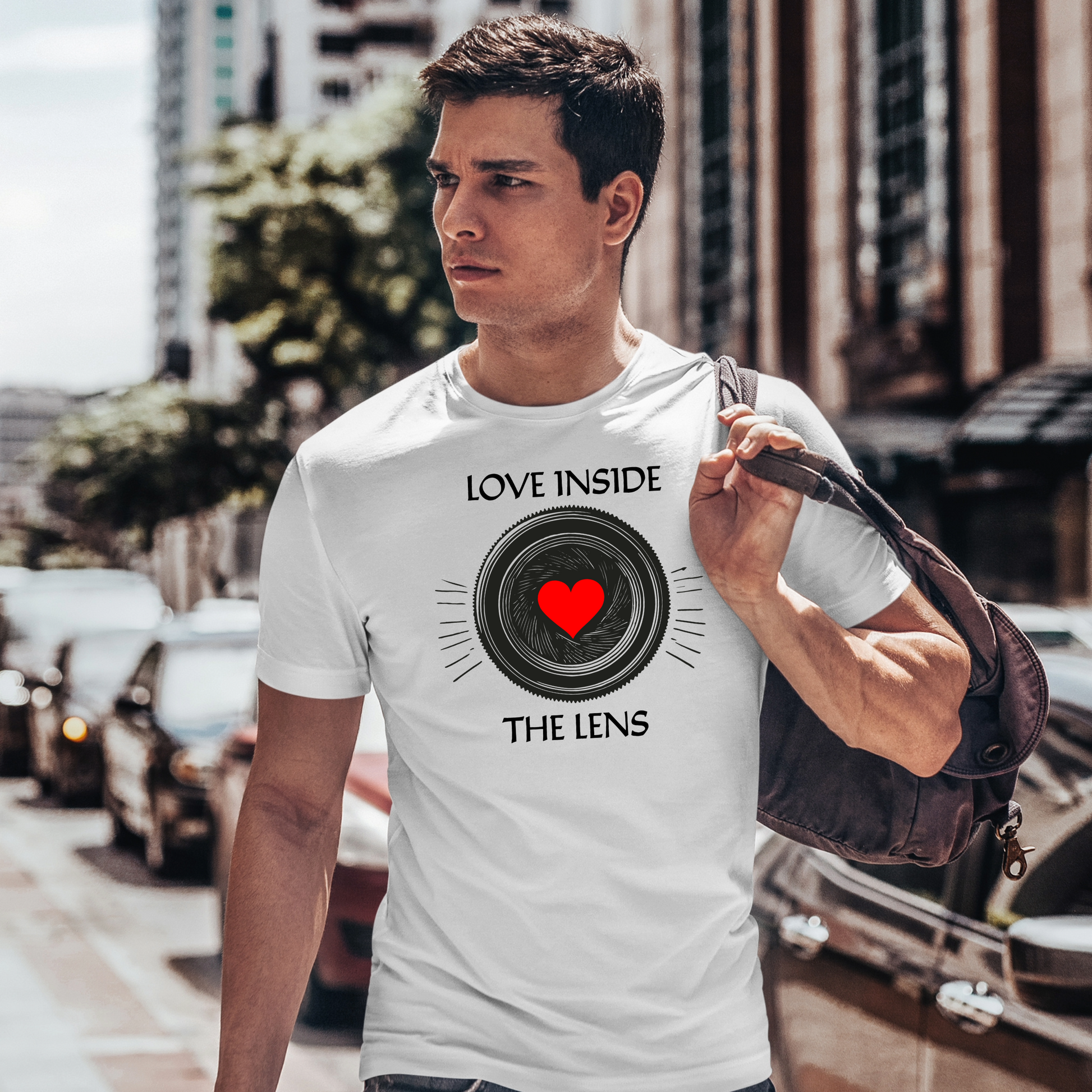 maglietta indossata da un uomo in città: T-shirt unisex "Love Inside The Lens" in cotone bianco, indossata in un contesto urbano. Ideale per chi ama esprimere la propria passione per la fotografia con stile