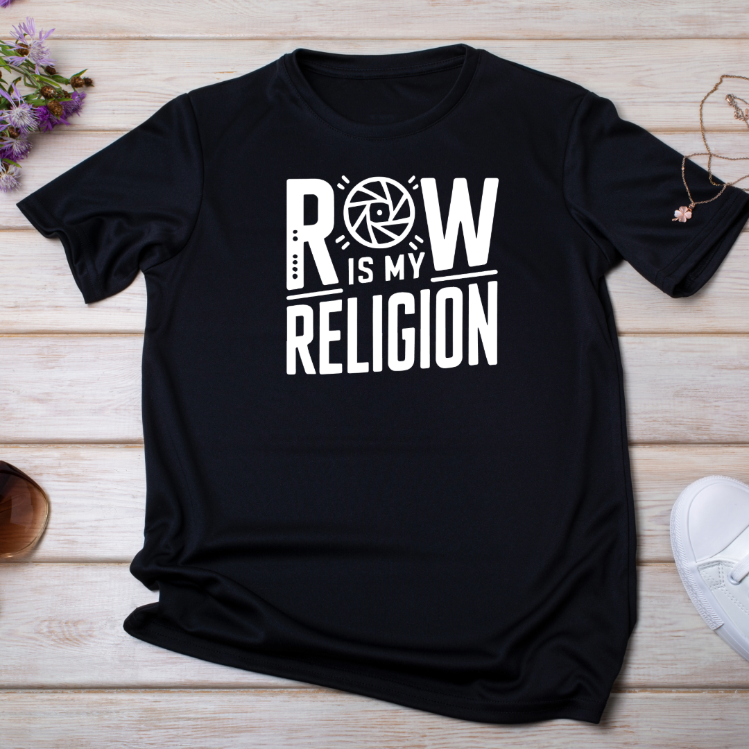  Maglietta "RAW is My Religion" nera, appoggiata su una superficie in legno con occhiali da sole e accessori minimal.