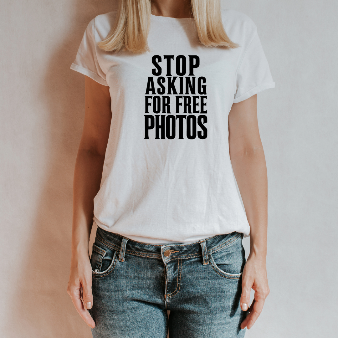 (T-shirt indossata da una donna con sfondo neutro):
"Donna che indossa la t-shirt bianca 'Stop Asking for Free Photos', perfetta per fotografi professionisti che vogliono far valere il loro lavoro."